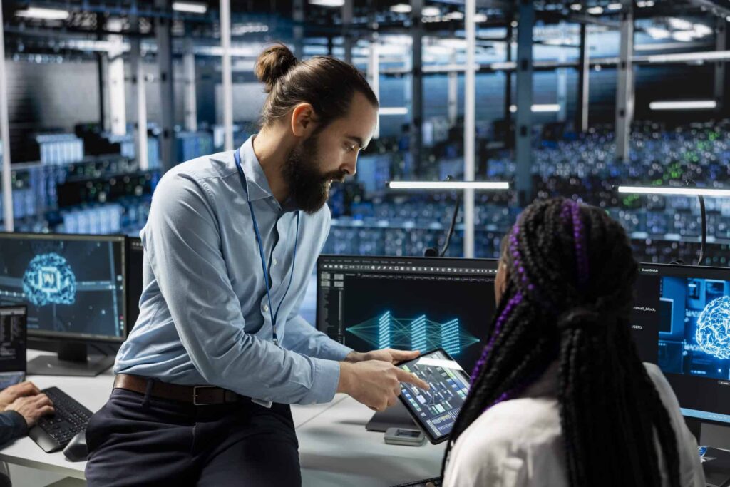Team leader showing data on a tablet to a colleague in a high-tech workspace - CMIT Solutions GDPR compliance guide for businesses in the US
