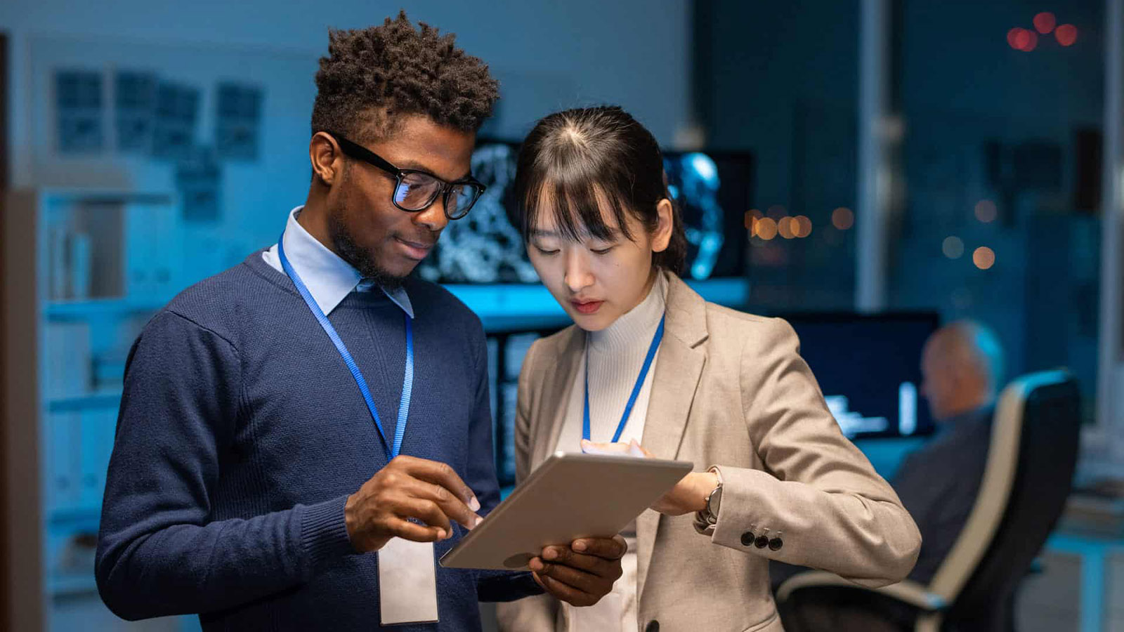 Two-coworkers-standing-together-reviewing-information-on-a-tablet-in-an-office CMIT Solutions What Is PCI-DSS Compliance? Requirements, Checklist & More Two-coworkers-standing-together-reviewing-information-on-a-tablet-in-an-office