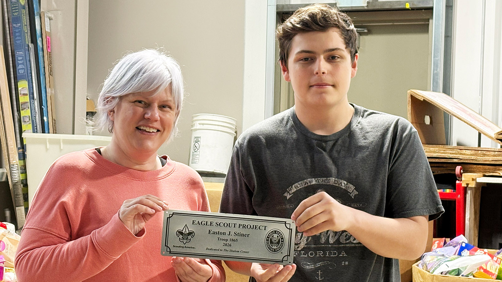 2026-06-01-Shalom-Center-Roberts-Stiner 2 xecutive Director Esther Roberts and Easton Stiner holding his service project plaque - Kenosha Eagle Scout Builds Garden for Shalom Center